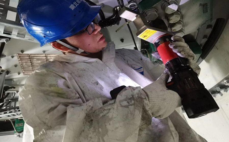 運(yùn)維人員袁才波正在狹小的空間內(nèi)打力矩(攝影:張鍵鍵) 運(yùn)維人員袁才波正在狹小的空間內(nèi)打力矩(攝影:張鍵鍵)